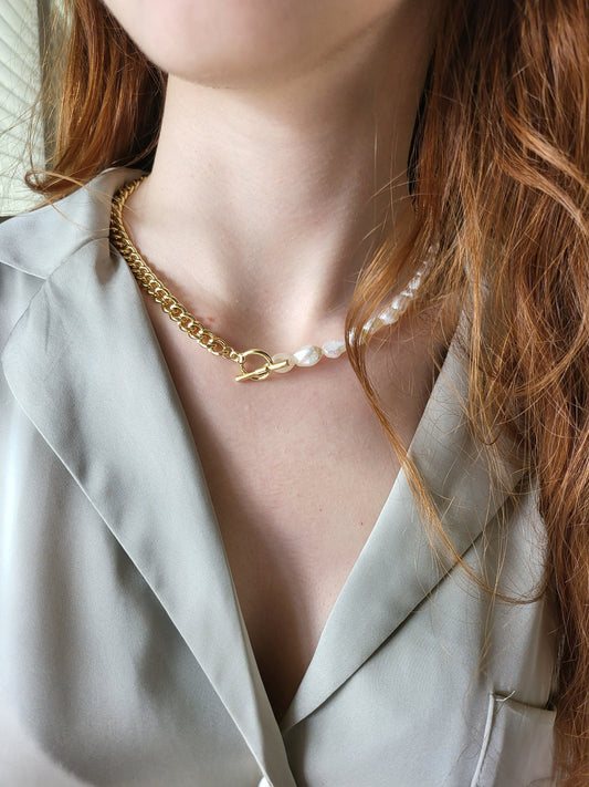 May include: A gold chain necklace with a toggle clasp and a pearl strand attached to the clasp.